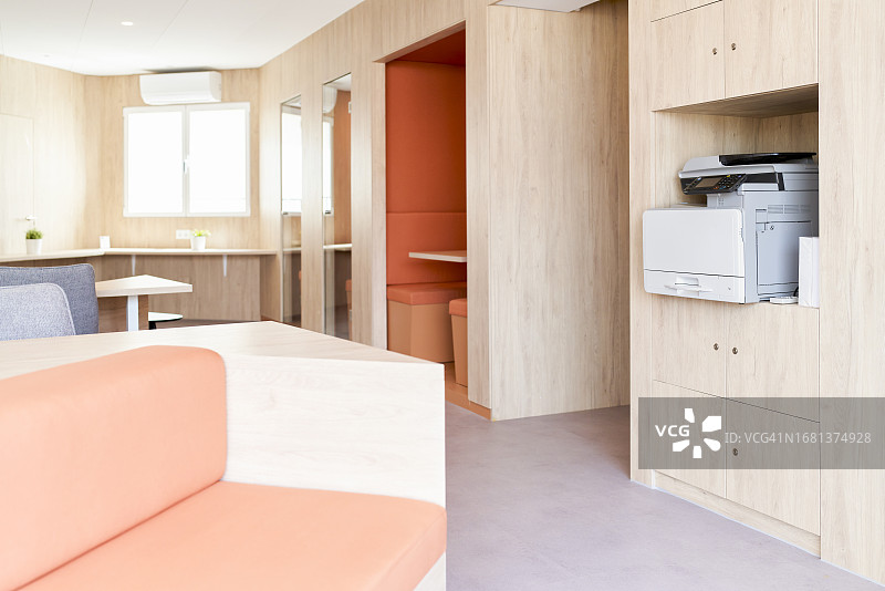 带橱柜、窗户、空调和复印区的办公室内部图片素材