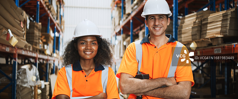 年轻白人男子和非裔女人仓库工人，面带笑容图片素材