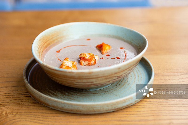 餐桌上的奶油浓汤和面包丁正面图图片素材