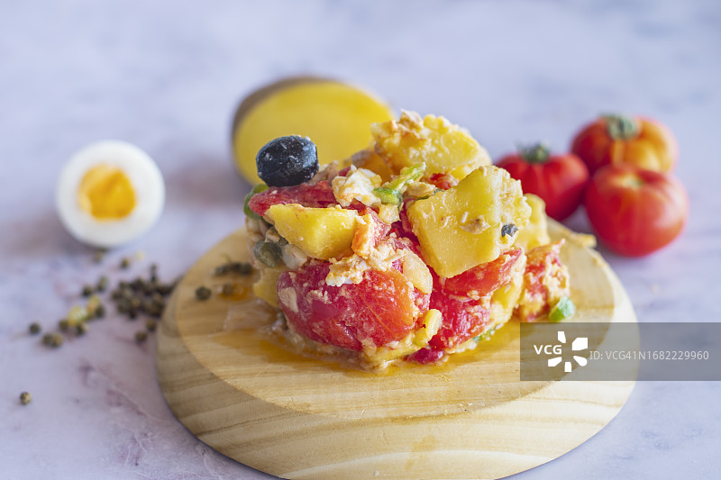 夏季沙拉：以土豆、腌金枪鱼、煮鸡蛋、橄榄、青椒和洋葱为基础图片素材