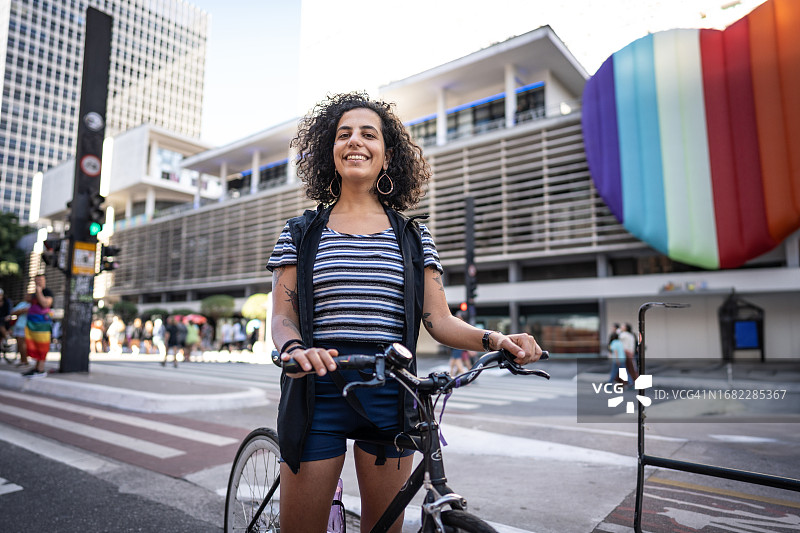 年轻女游客在城市里骑自行车的肖像图片素材