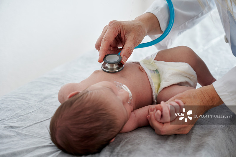 医生用听诊器检查婴儿图片素材