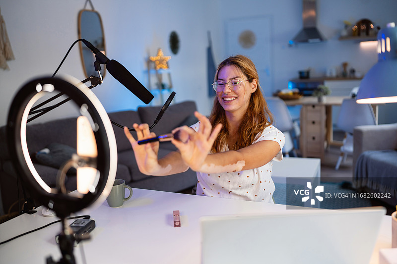 患有白癜风的红发白人美女网红正在录制美妆视频图片素材