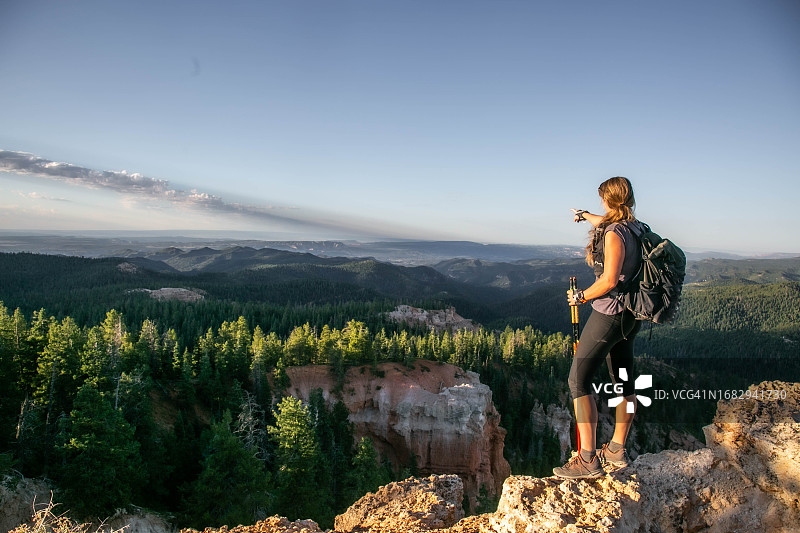 穿着运动服指向地平线的女人图片素材