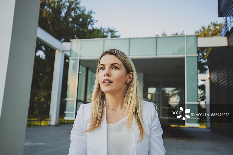 站在建筑物外面的金发女子半身像图片素材