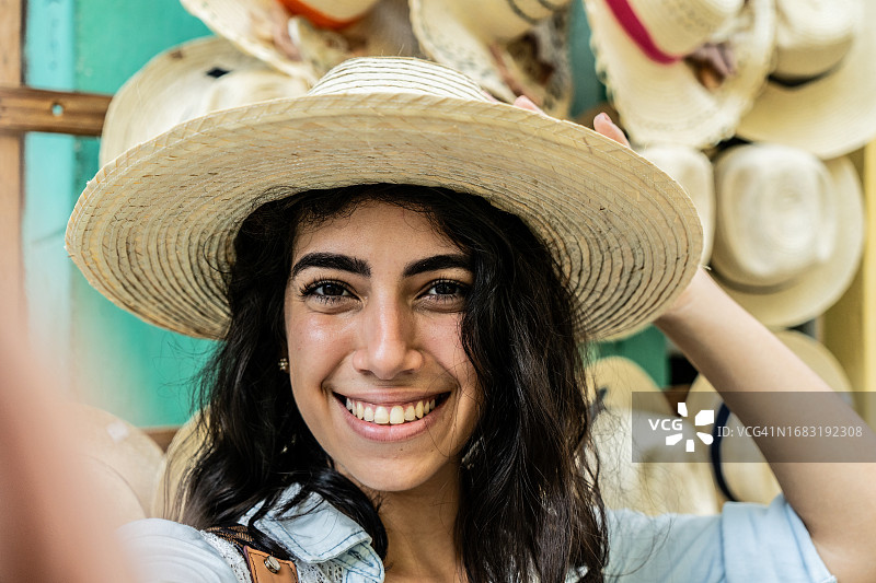 年轻女人在户外戴着太阳帽自拍图片素材