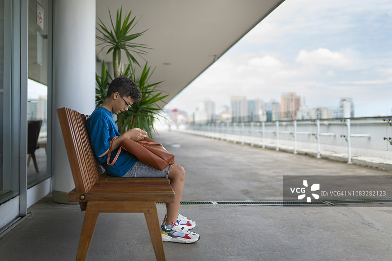 男孩坐着玩手机图片素材