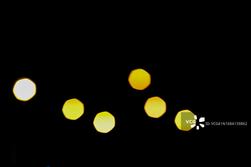 夜晚汽车前灯的黄色模糊光圈图片素材