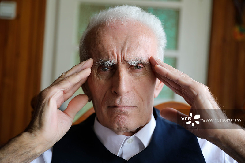 一位患有偏头痛的老年男人的局部照片图片素材