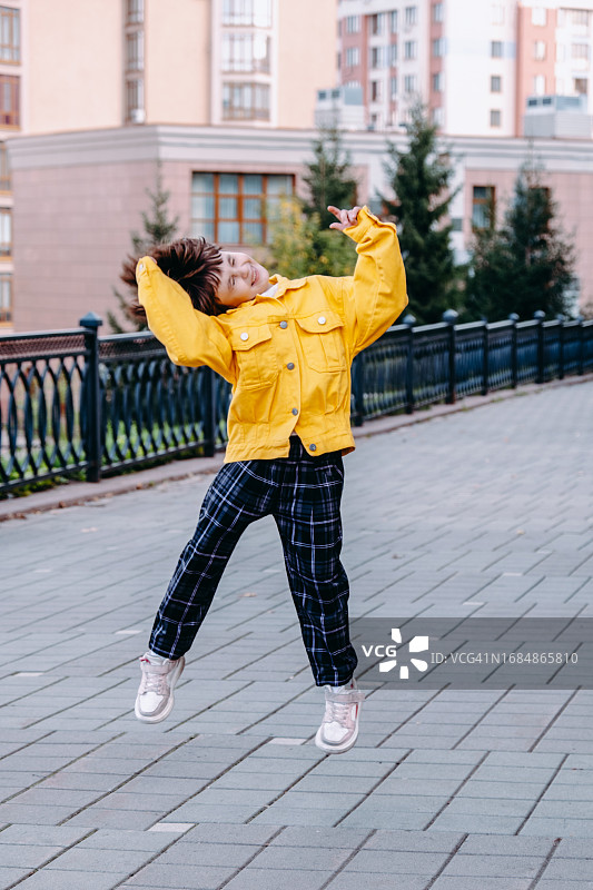 快乐的小女孩在街上跳舞，享受夏日乐趣图片素材