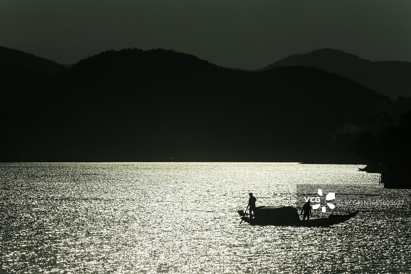 越南中部香江上捕鱼的渔民剪影图片素材