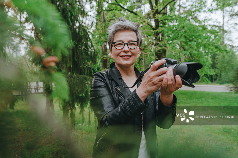 在户外拍照的灰发中年妇女图片素材