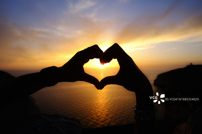 阳光下的手捧心形图片素材