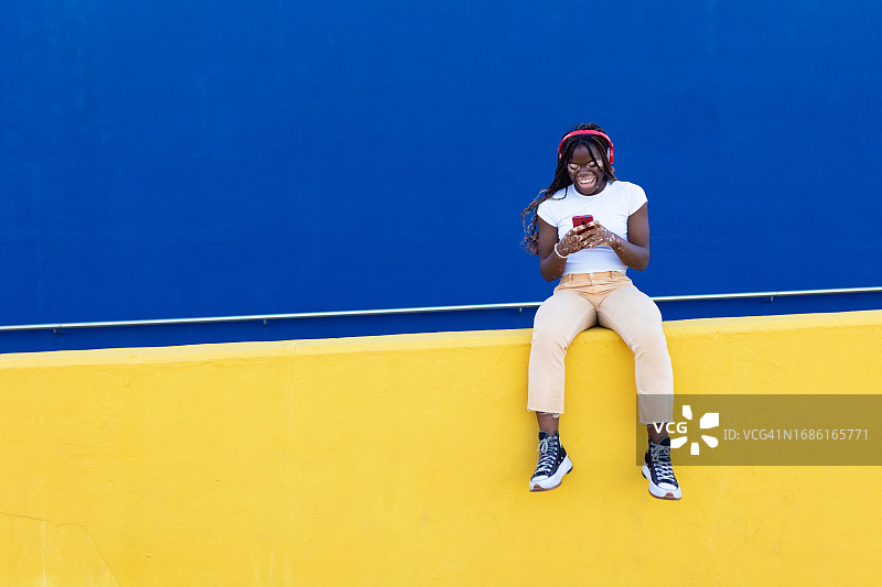 快乐的年轻黑人女人患白癜风用手机听音乐图片素材