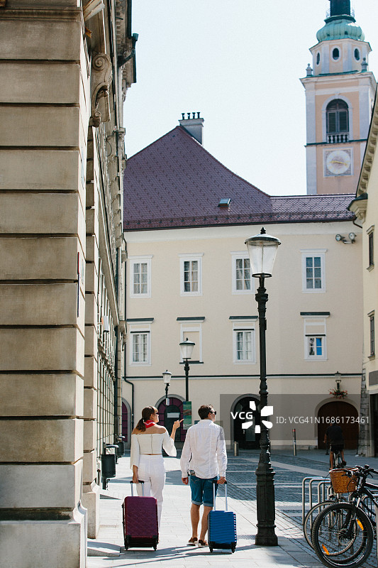两个朋友在市中心带着行李行走图片素材