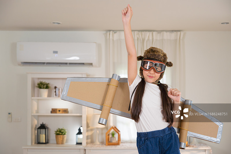 带着火箭翅膀，假装在天空中飞翔的可爱女孩图片素材