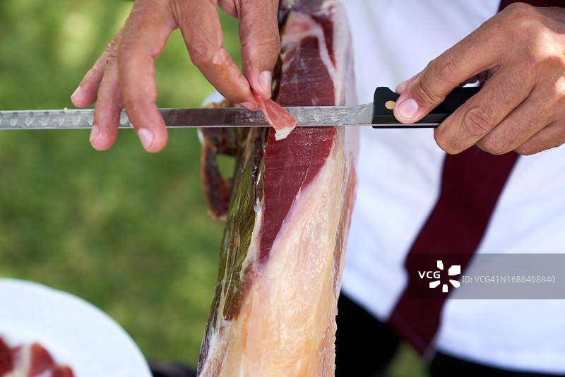 在花园工作的专业伊比利亚火腿切割师图片素材