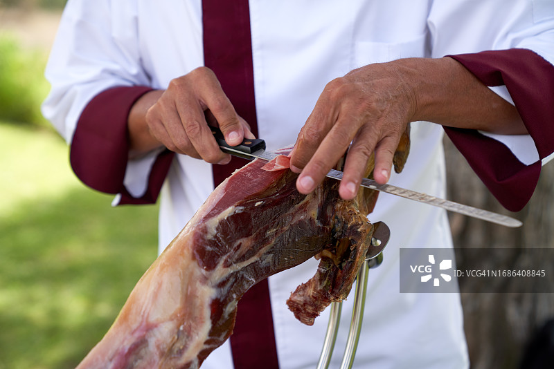 在花园工作的专业伊比利亚火腿切割师图片素材