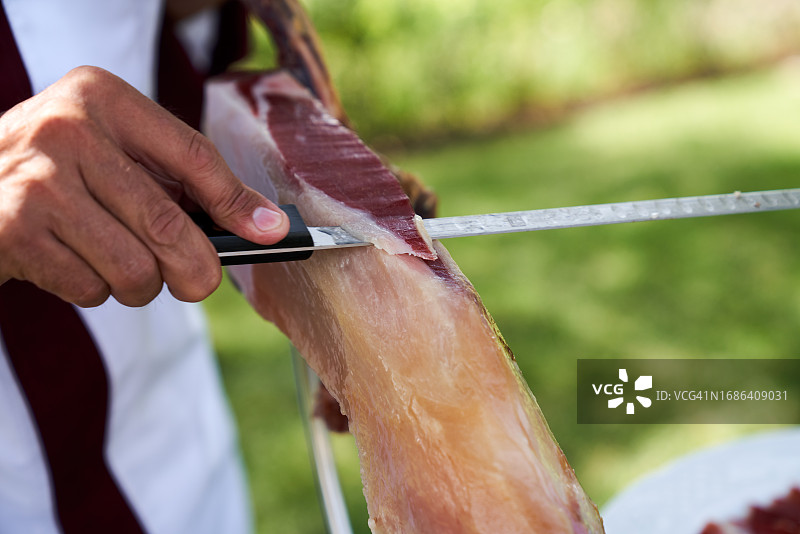 在花园工作的专业伊比利亚火腿切割师图片素材