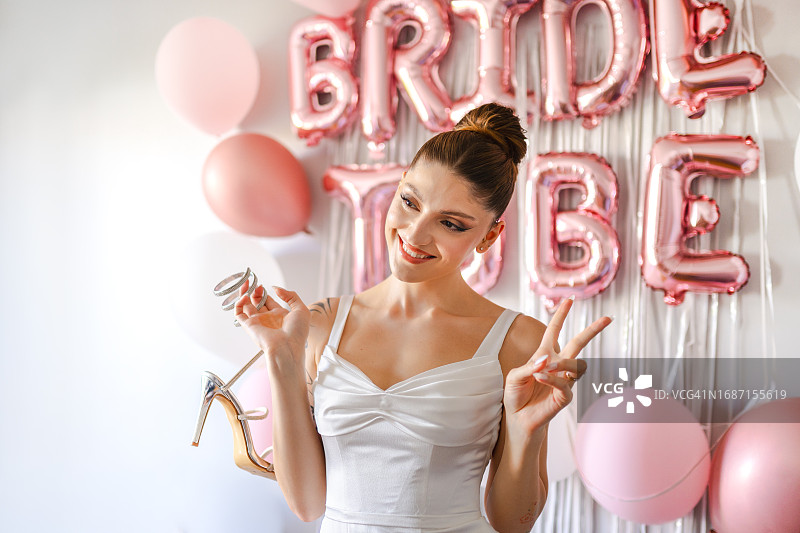 年轻新娘在婚鞋底部写下单身朋友的名字图片素材