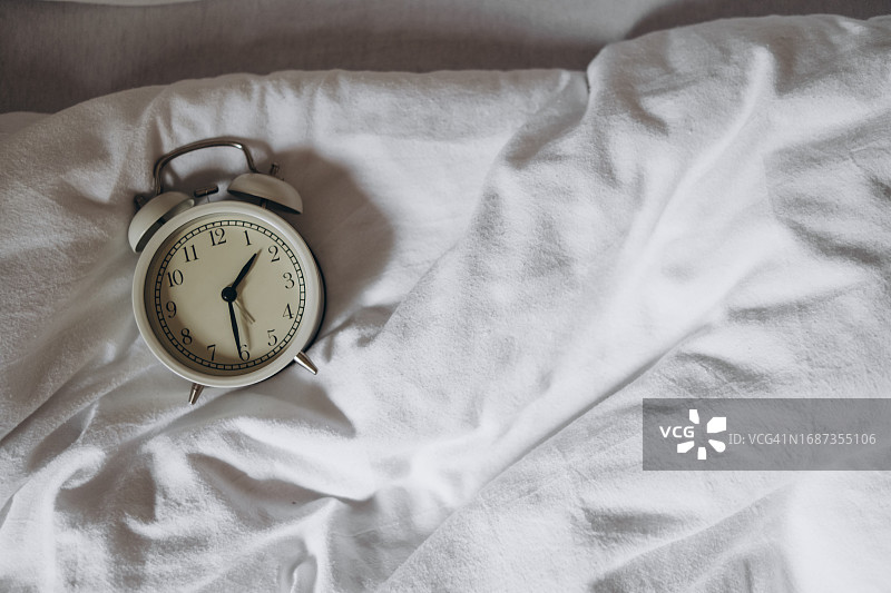 床上的白色闹钟图片素材