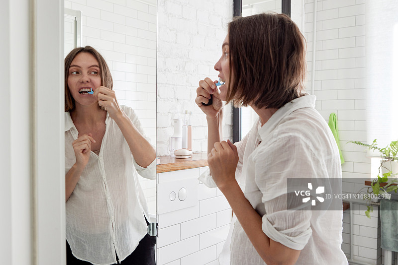 女人在家里的浴室用牙签剔牙图片素材