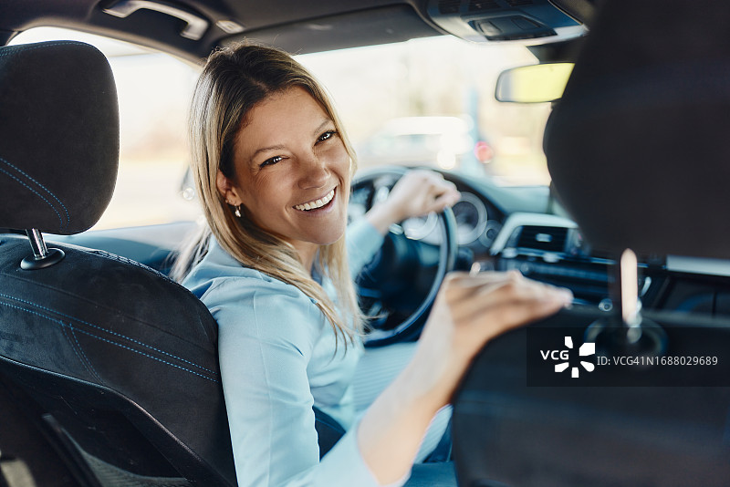 坐在车里的年轻快乐女商人图片素材