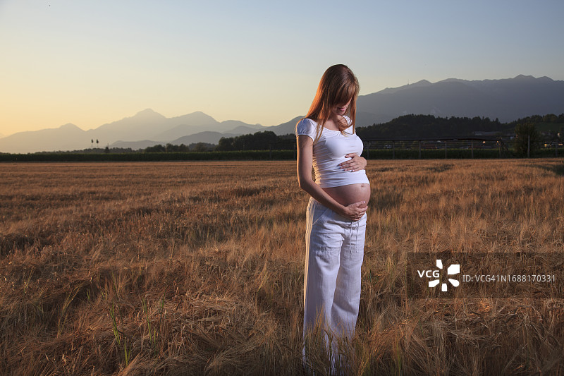 孕妇在田野里享受图片素材