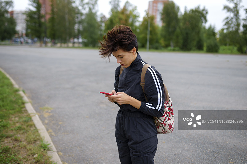 在城市街道上使用智能手机的年轻女人图片素材