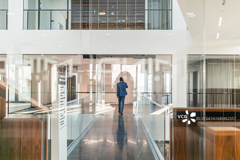 商人在办公楼走廊里使用手机图片素材