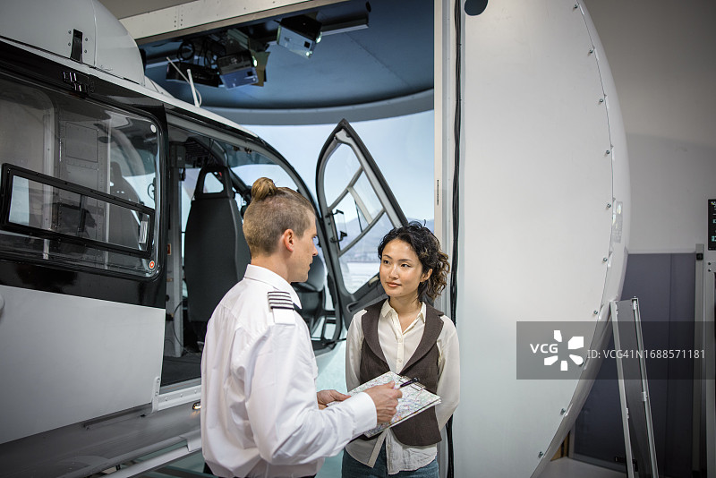 飞行员在直升机训练设施中与学生交谈并为她准备一天的训练图片素材