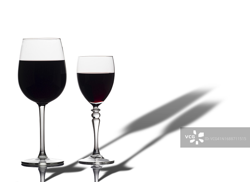 白色背景下带有长阴影的两杯红葡萄酒图片素材
