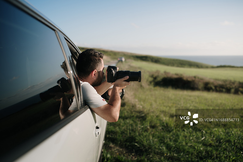 在车里使用单反相机的男人图片素材