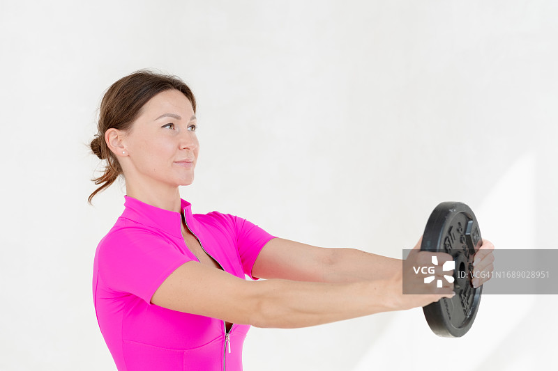 穿着粉色连体裤手持铁环的37岁女人图片素材