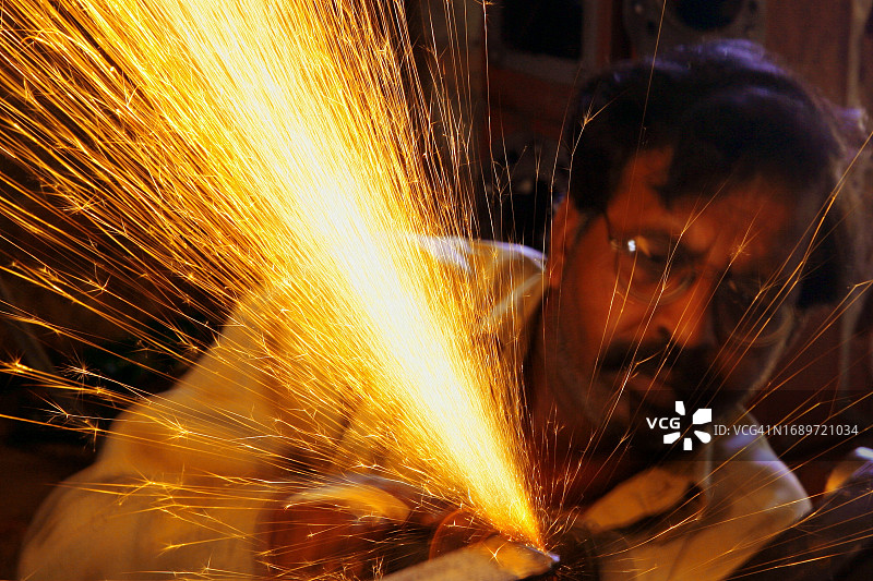 在车间工作的金属工人打磨铁器头像图片素材