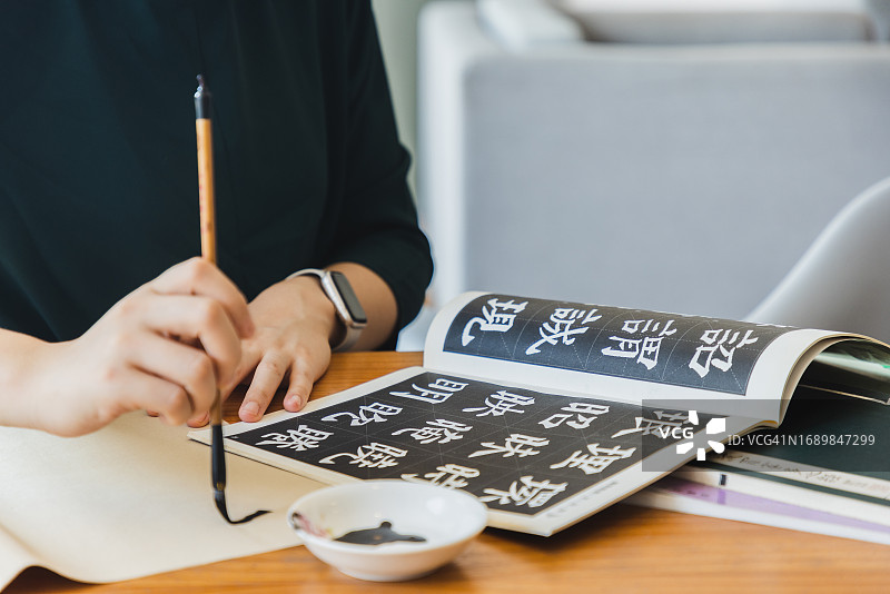 在家练习中国书法的亚洲女人图片素材