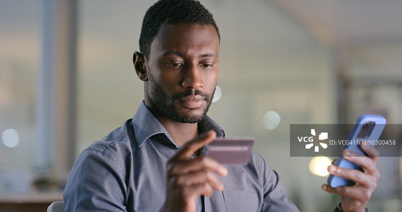 商务场景：黑人男子在办公室用手机进行电商、预算或贷款支付，信用卡支付。智能手机应用程序，非洲男性经理进行在线购物、客户体验或现金返还调查图片素材