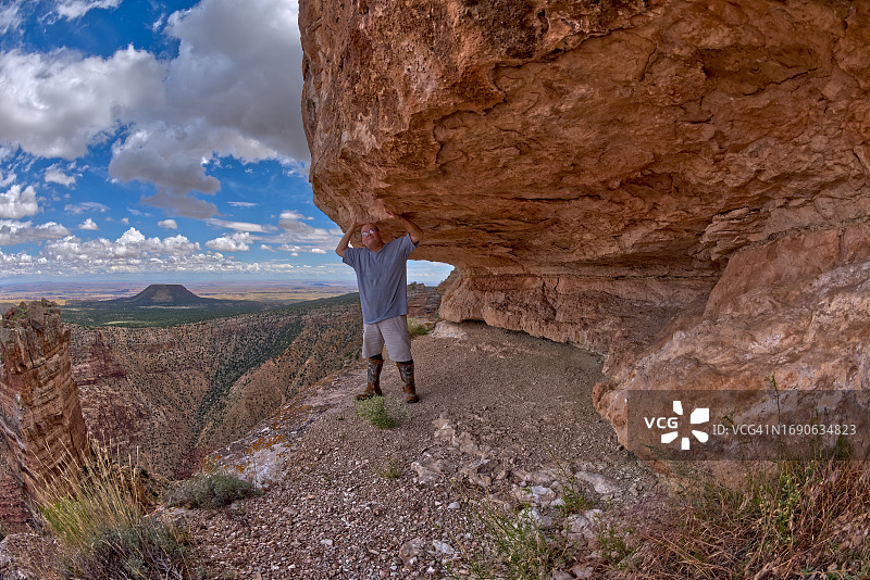 男人站在美国亚利桑那州大峡谷国家公园沙漠景观点的悬崖下图片素材