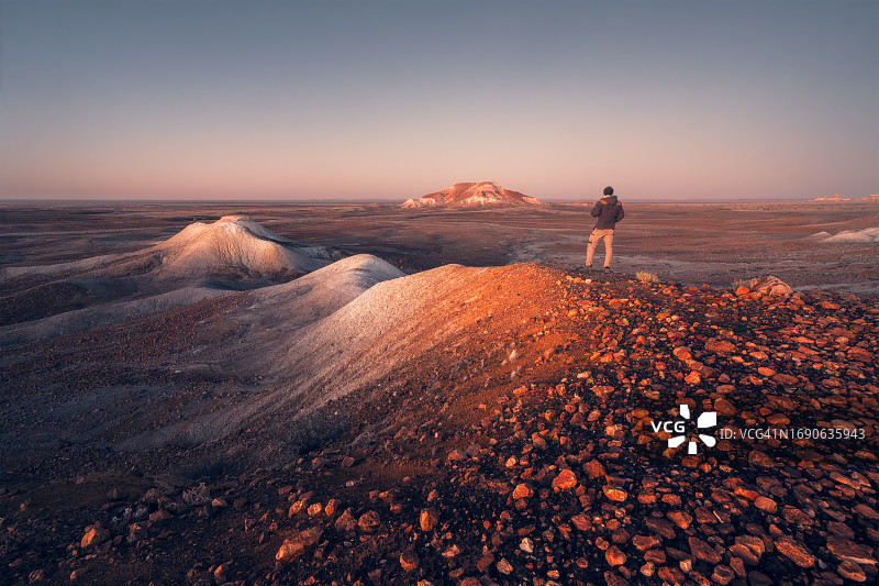 男子站在岩石上，看着澳大利亚偏远地区的日出图片素材