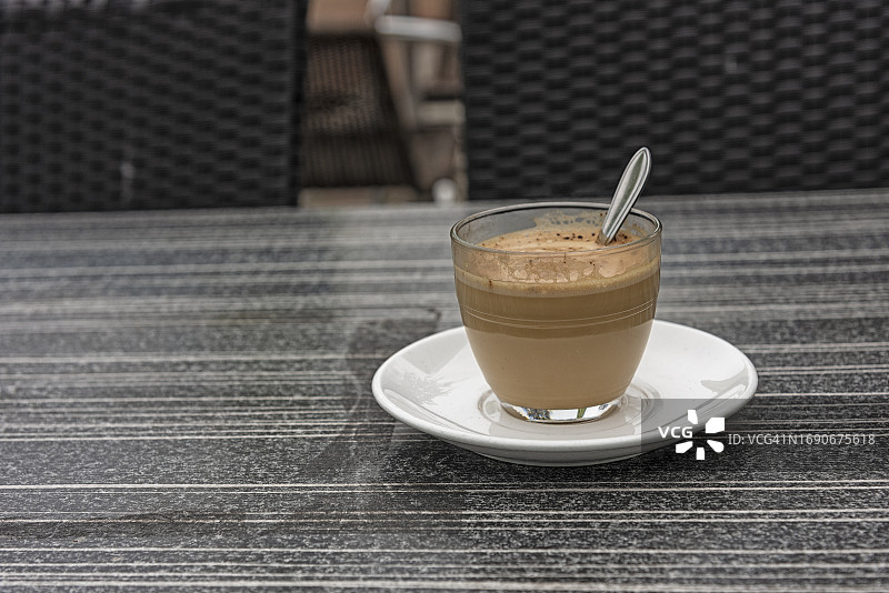 白色茶托上的咖啡玻璃杯和勺子图片素材