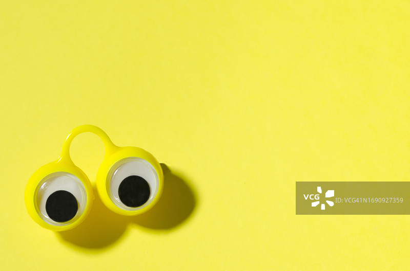 黄色背景上的卡通眼睛，带有复制空间图片素材