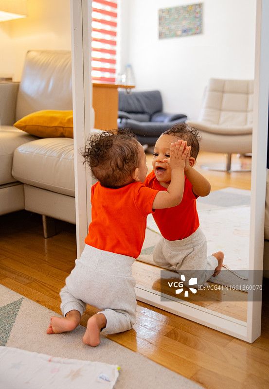 八个月大的宝宝在玩镜子图片素材
