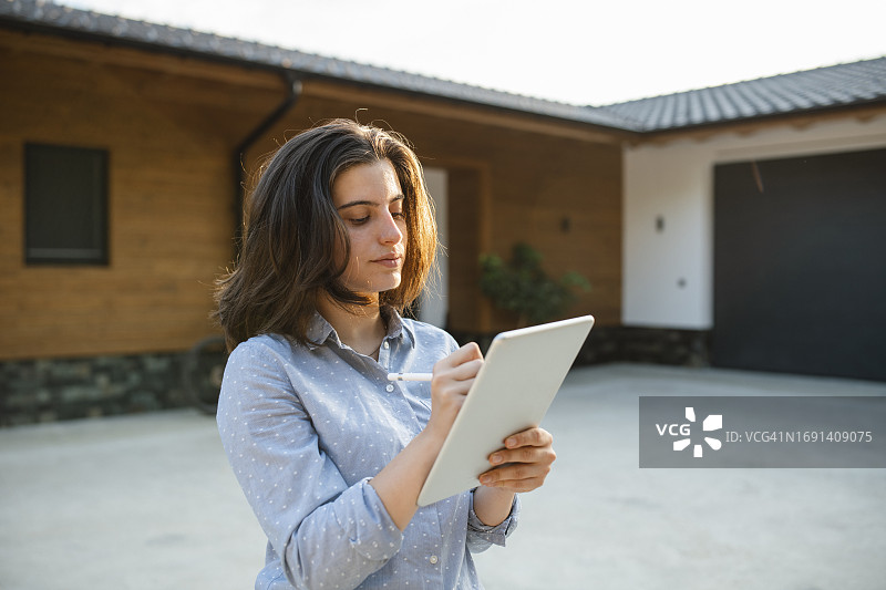 保险理算员使用平板电脑检查房屋图片素材