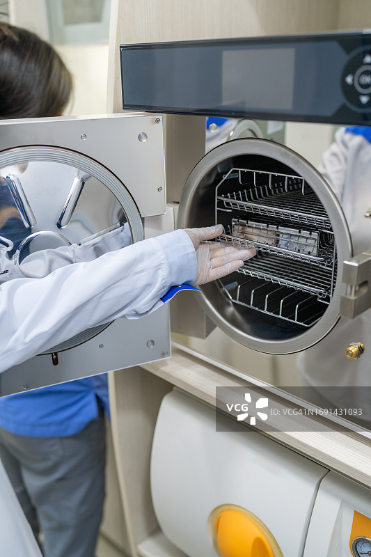 身份不明的牙医用机器对设备进行消毒图片素材