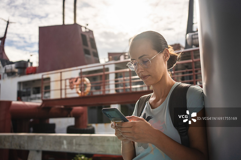 女人在码头使用智能手机图片素材