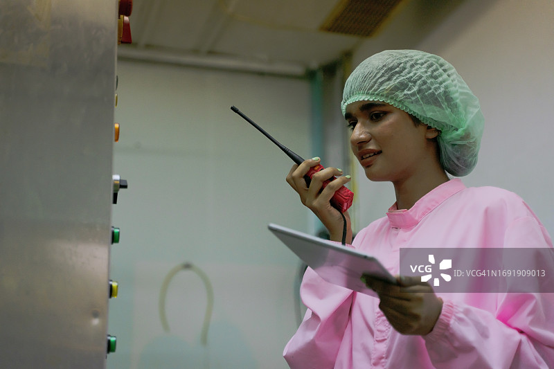 在饮料制造厂工作的蓝领工人图片素材