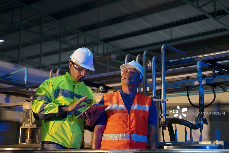 在饮料制造厂工作的蓝领工人图片素材