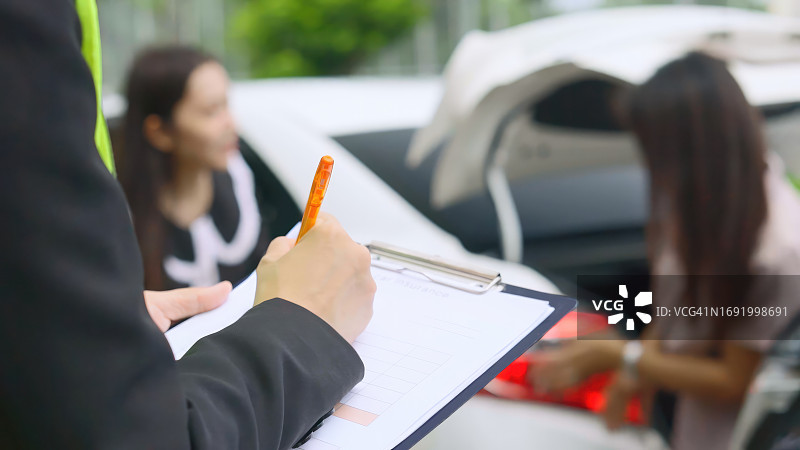 保险代理人在车祸后做笔记并收集信息的特写图片素材