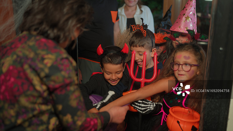 一群小朋友在夜晚收集万圣节糖果图片素材