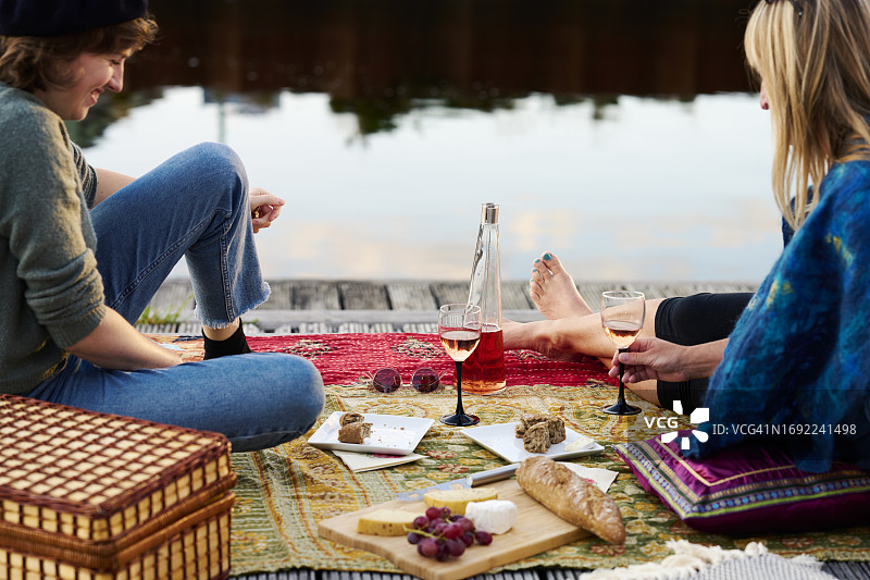 野餐毯上的面包、葡萄酒和奶酪图片素材